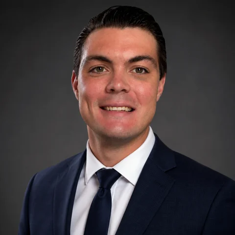 Adam Hunt, founder of Hunt Premier Landscaping, wearing a dark suit and tie