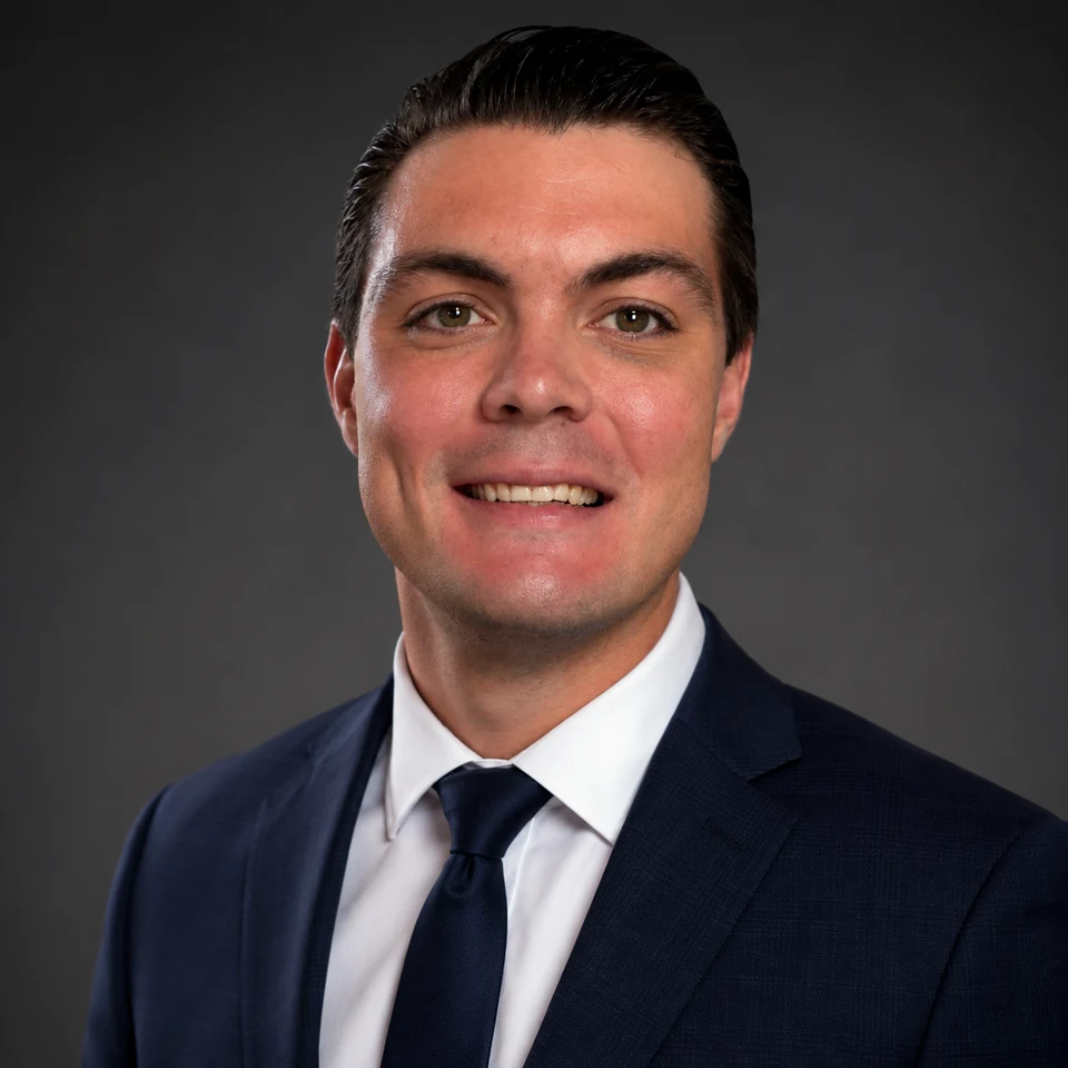 Adam Hunt, founder of Hunt Premier Landscaping, wearing a dark suit and tie