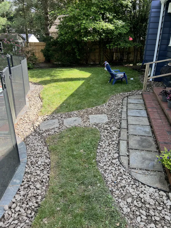 Backyard Path & Bed Restoration in Audubon, NJ — River-rock beds with clean-cut edges now frame the stepping-stone path, walkway, and lawn.