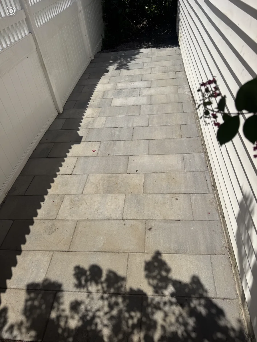 A paver walkway runs the full length of the side yard, between the fence and the house in Haddonfield, New Jersey.